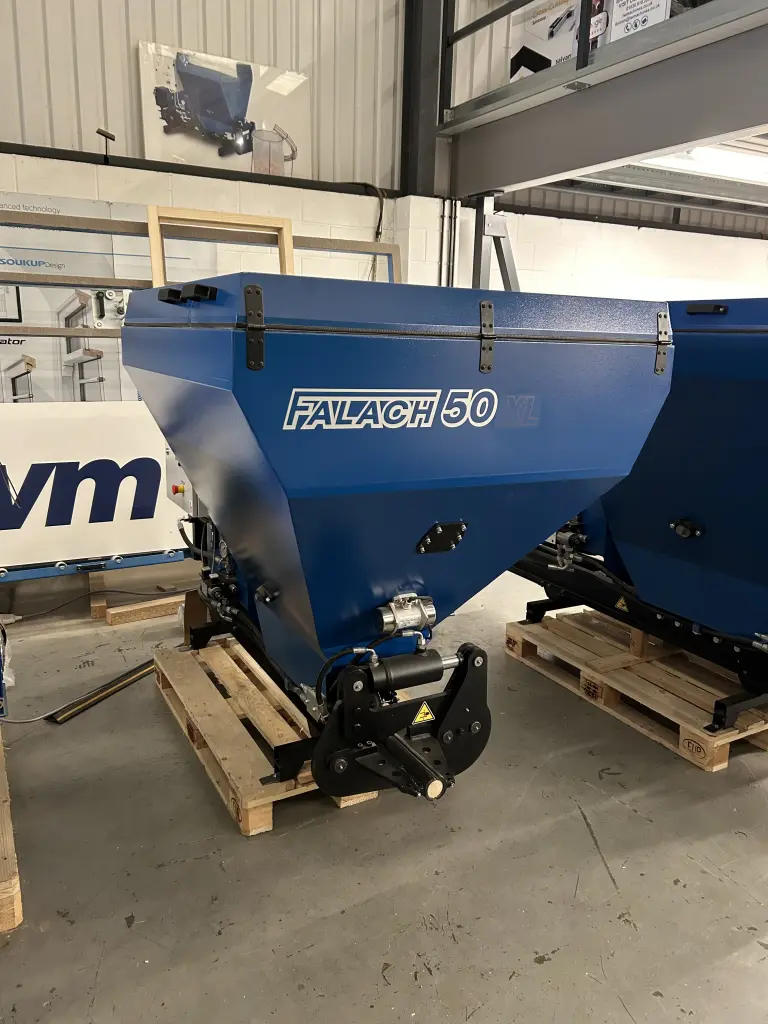 Falach 50XL blue briquette machine on a wooden pallet inside an industrial warehouse