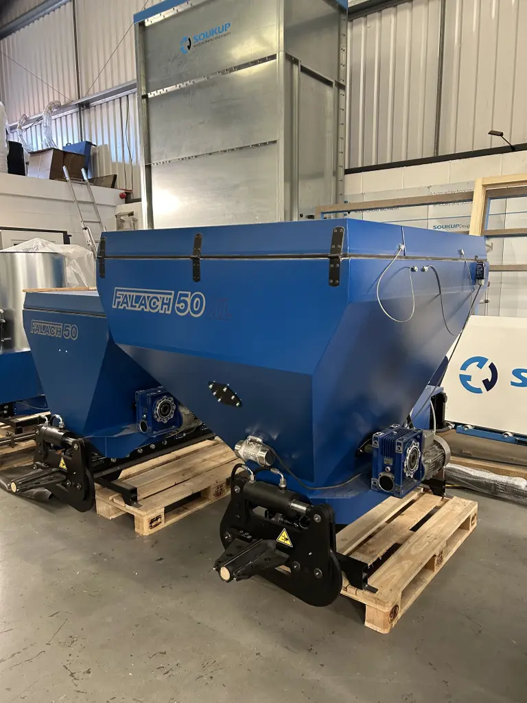 Two blue Falach 50 briquette machines on wooden pallets inside a warehouse