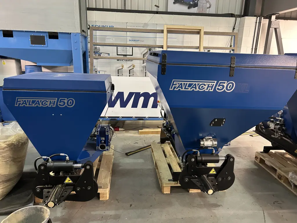 Two blue Falach 50 briquette machines on wooden pallets inside an industrial workshop
