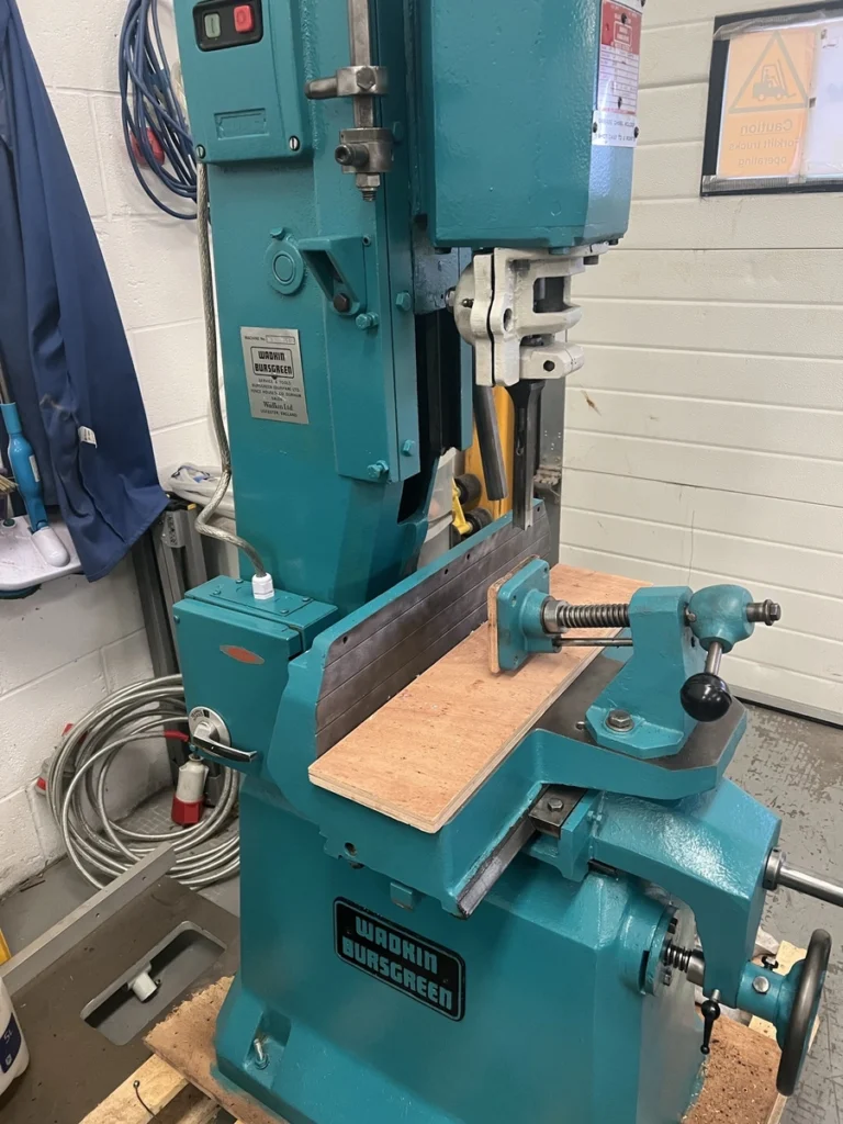 Fully refurbished teal Wadkin Bursgreen mortising machine with timber workpiece clamped on the table in a workshop
