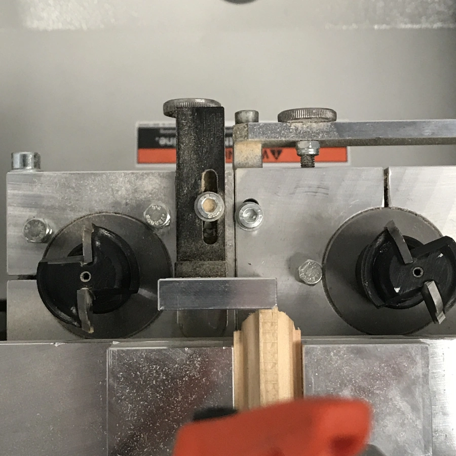 Close-up of a HEP glazing bead end profile scribing machine cutting a wooden bead with twin cutter heads