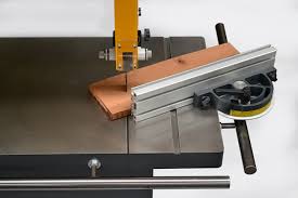 Closeup of an IWM UK bandsaw range machine cutting a copper-coloured workpiece on a metal table