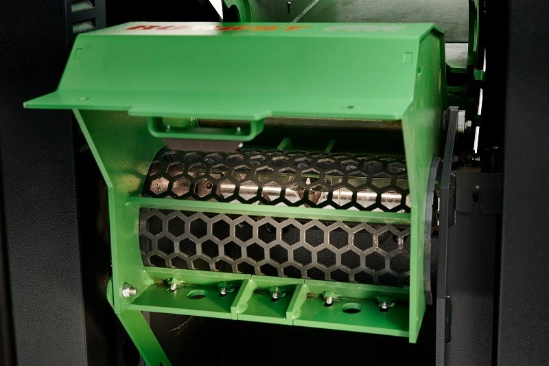 Close-up of a green Robust REUSER SD450 wood shredder showing a hexagonal-patterned drum and cutting mechanism