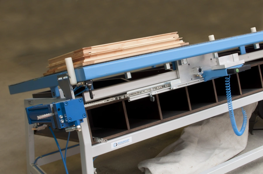 Soukup Assembling Table KS 2400 with blue frame, timber strips stacked on top, pneumatic fittings and segmented storage below