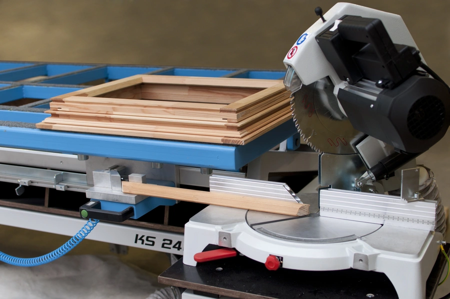 Soukup KS 2400 assembling table with a mitre saw and timber door frame components on a blue work surface