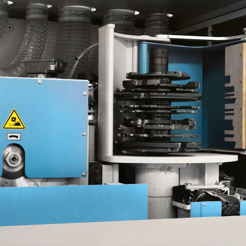 Close-up of a Soukup Crafter CNC window machining centre showing stacked cutting tool discs and blue safety housing