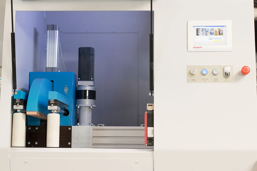 Soukup Crossline 500 cross cut saw with blue cutting head, pneumatic cylinder, and Beckhoff control panel with emergency stop button