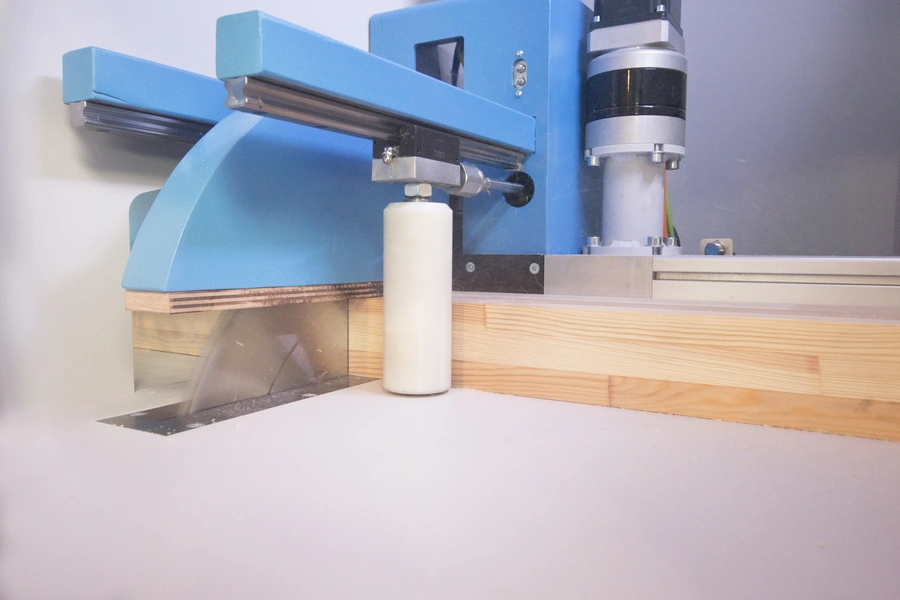 Blue Soukup Crossline 500m cross cut saw cutting through a pine timber plank with dust visible