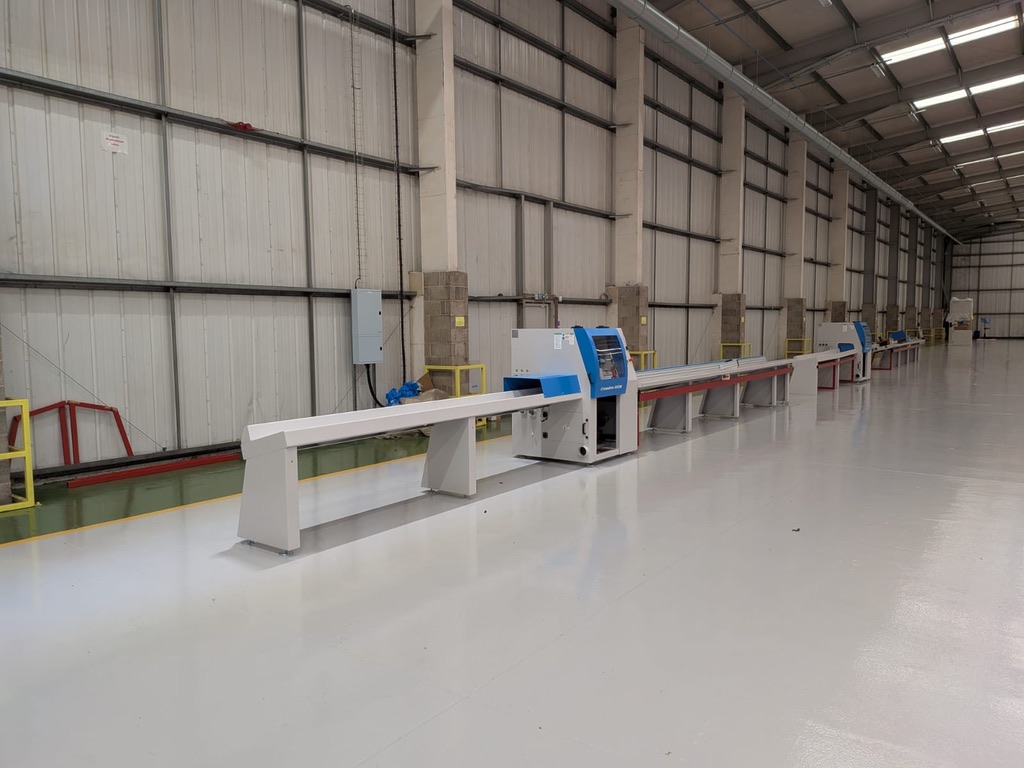 Soukup Crossline 500m cross cut saw mounted on a long white feed rail inside a large industrial warehouse