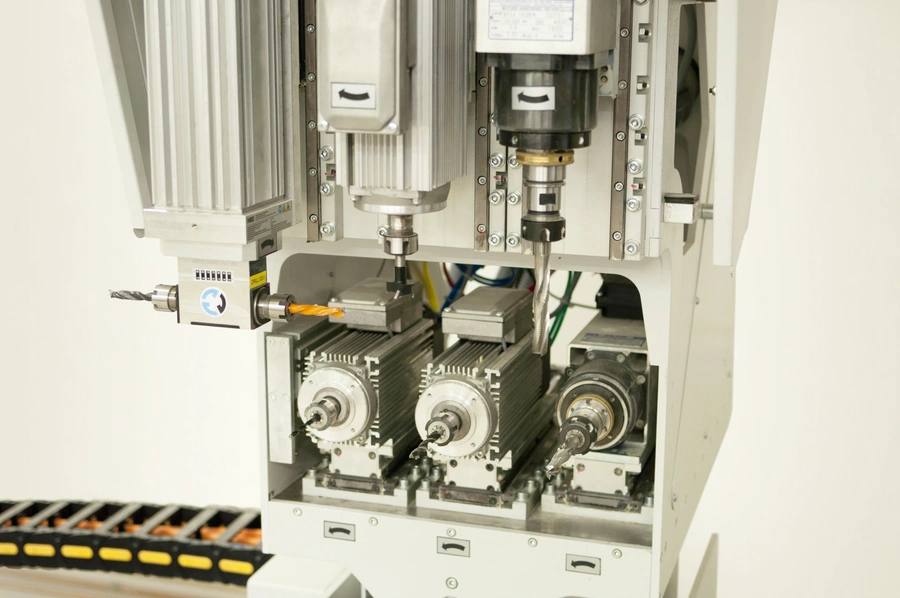 Close-up of a Soukup Drillex Work Centre showing multiple spindle motors and drill bits on a CNC machining unit