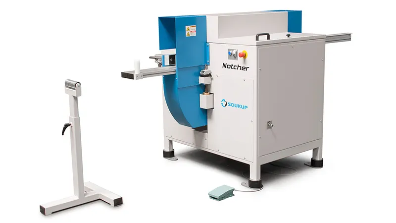 Soukup Notcher machine in blue and grey with a foot pedal and adjustable roller stand on a white background