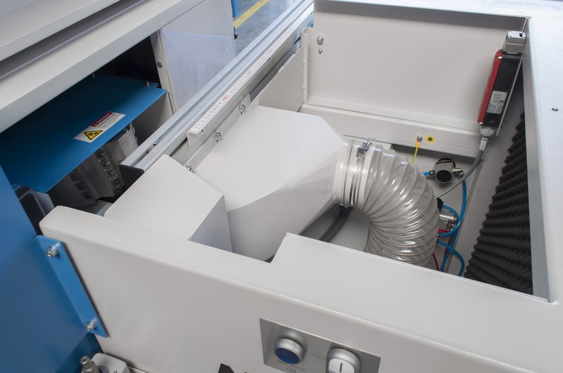 Interior of a Soukup Notcher machine showing a flexible extraction duct, wiring, and acoustic foam lining inside an open panel