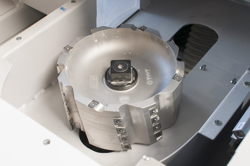 Large circular milling cutter with carbide inserts mounted inside a Soukup Notcher machine