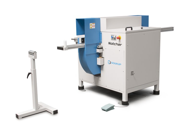 Soukup Notcher machine in grey and blue with extended feed arms, a foot pedal, and a separate roller support stand