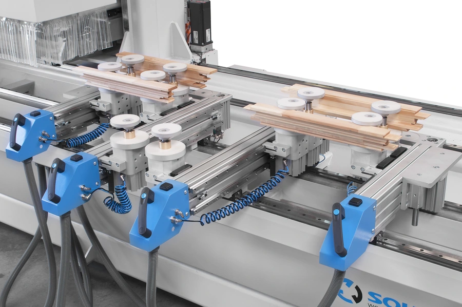 Soukup Spectra CNC working centre with blue clamps, white rollers, and timber strips secured on aluminium rail tracks