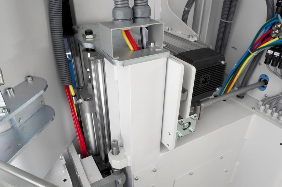 Internal machinery of a Soukup Temac automatic single end tenoning machine showing a servo motor, pneumatic cylinder, and multicoloured wiring