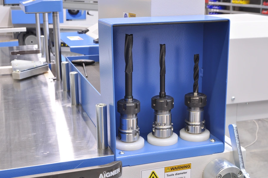 Three CNC cutting tools with collet holders stored upright in a blue tool storage compartment on a Soukup Versa machine