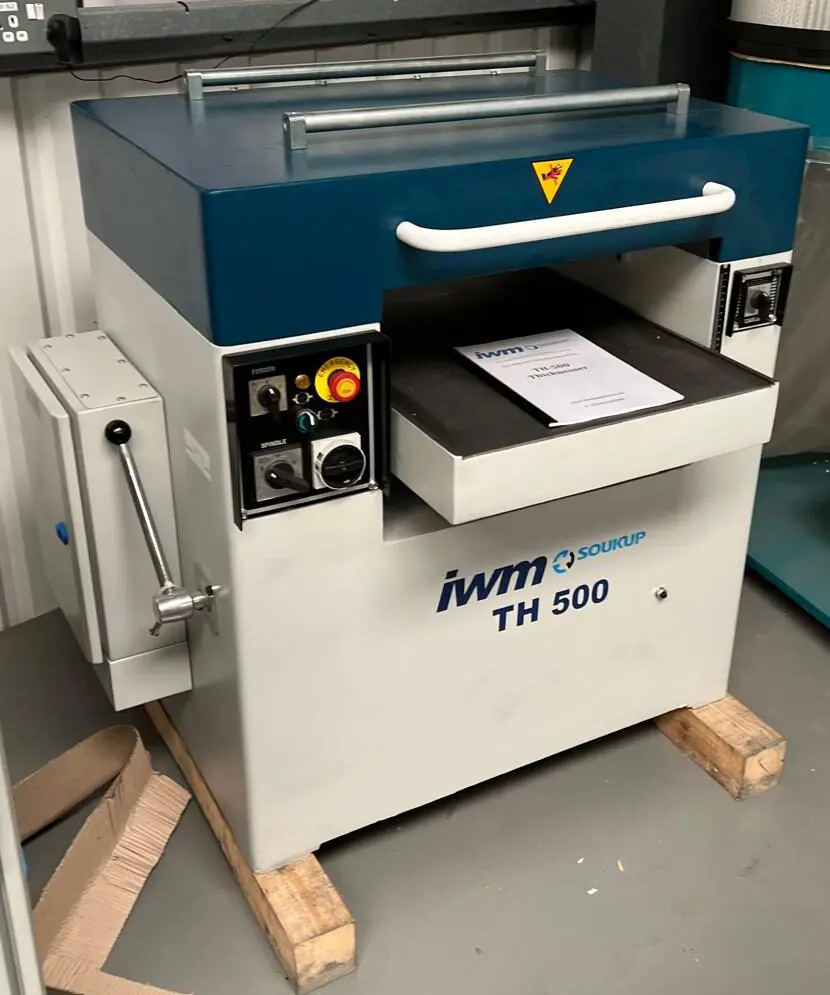 IWM Soukup TH 500 thicknesser machine with blue top housing, control panel, and feed table, resting on wooden pallets