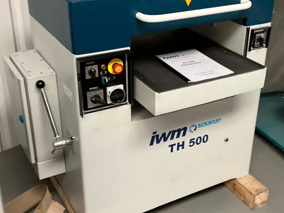 IWM Soukup TH 500 thicknesser machine with blue top housing, control panel, and feed table, resting on wooden pallets