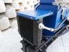 Close-up of a blue Falach 70 briquette machine showing a black oil cooler radiator with hydraulic hoses and fittings