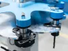 Close-up of blue and silver industrial machinery components with precision bearings and metal spindles