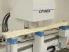 Soukup Drillex work centre machine processing a length of pale timber on its blue and white feed bed