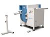 Soukup Notcher machine in grey and blue with extended feed arms, a foot pedal, and a separate roller support stand