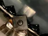 Close-up of a carbide cutting insert secured by a central screw on the rotor of an industrial shredder