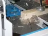 Timber being cross cut and trenched on a Soukup Crossline 650m automatic angle saw, with wood shavings scattered across the machine bed