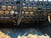 Close-up of a black perforated drum on a REUSER SD600 shredder with wood shavings and debris scattered below