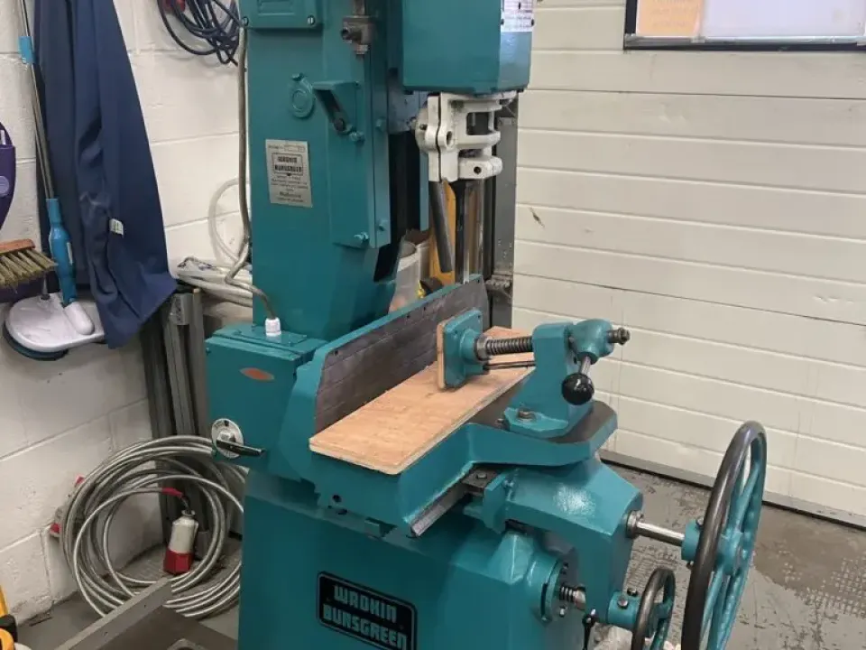 Wadkin Bursgreen chain morticing machine in teal, sitting on a wooden pallet in a workshop
