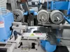 Close-up of blue Soukup fourside planer and moulder machine showing serrated cutter heads and danger warning labels