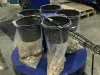 Falach 50 briquette machine in a workshop, with four black hoppers filled with compressed material briquettes in plastic bags
