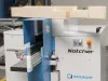 Soukup Notcher machine with a timber beam positioned above the blue and white woodworking unit in a workshop