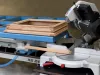 Soukup KS 2400 assembling table with a mitre saw and timber door frame components on a blue work surface