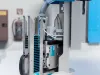 Close-up of a BeA Autotec automated stapling machine unit mounted on a blue industrial frame with castors