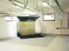 Industrial wood finishing spray booth with extractor ducting and overhead hanging rails in a workshop