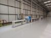 Soukup Crossline 500m cross cut saw mounted on a long white feed rail inside a large industrial warehouse
