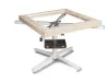 Soukup frame assembling equipment with a square wooden frame held on a white metal cross-base stand with central metal clamp mechanism