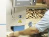 A woodworker operating a Soukup Crafter CNC window machining centre with timber offcuts stacked in the background