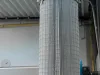 Cylindrical pleated filter cartridge mounted on a blue Pontec industrial dust extraction machine in a workshop
