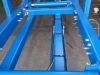 Blue-painted steel hydraulic stair cramp frame with four pistons, bolted cross members and hydraulic hose fittings, in a workshop