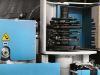 Close-up of a Soukup Crafter CNC window machining centre showing stacked cutting tool discs and blue safety housing