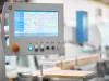 Touchscreen control panel of the Soukup Versa Max showing live X, Y, Z and A axis positions, spindle speed and drilling head status, with emergency stop and key switch below
