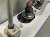 Close-up of a Copenstick end scribe machine spindle, bearing housing, and depth gauge for window beading profiles