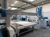 Pontec CNC machining centre with a large flat worktable holding a white panel, inside an industrial manufacturing facility