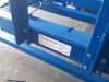 Close-up of a blue IWM Soukup hydraulic stair cramp frame with bolted steel sections, inside a workshop