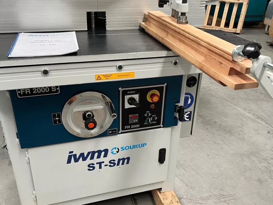 IWM Soukup ST-sm FR 2000 S sliding table spindle moulder with timber lengths on the worktop, in a workshop