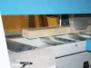 A timber length being fed through the roller conveyor bed of a Soukup Crossline 650 automatic angle cross cut saw.