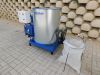 Cube 20 industrial briquette machine with blue steel frame, control panel, hydraulic components, and a collection bag on paved ground